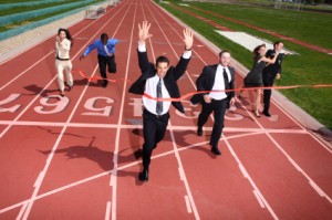 Business people crossing finish line. Wayne O'Neill and Associates