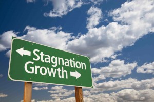 Stagnation or Growth Green Road Sign Over Dramatic Clouds and Sky.