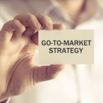Businessman holding up card for go to market strategy in 2021